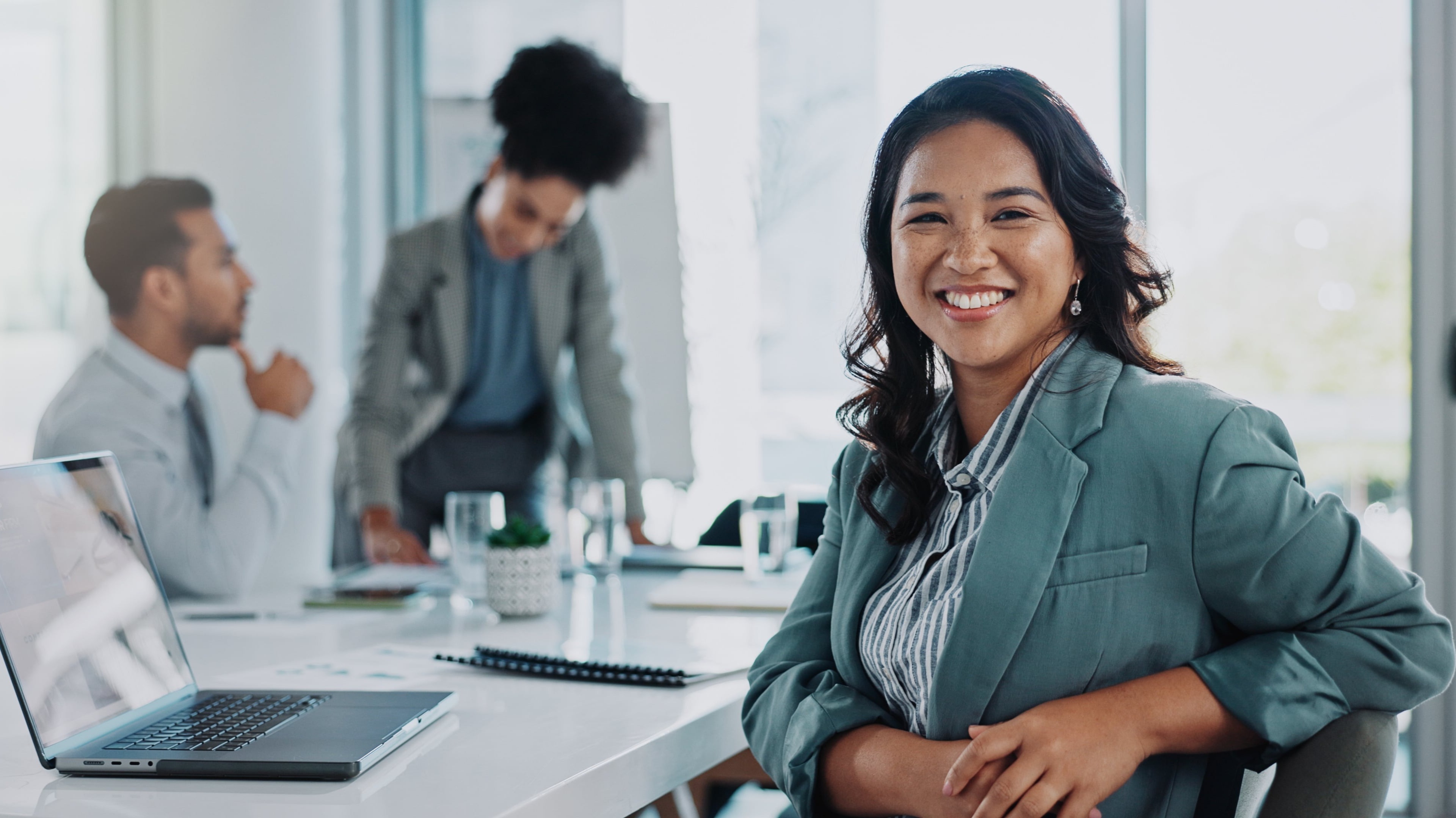 Woman smiling while in a meeting with a laptop