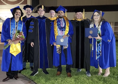 Group photo of students and faculty members in regalia.